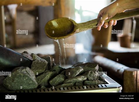Traditional Finnish Wooden Sauna In Details A Person Pouring Water Into Hot Stones With Big