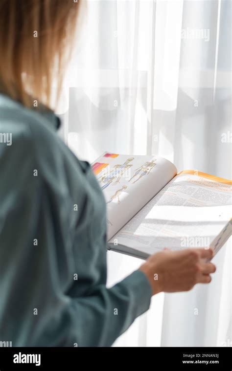 blonde médecin fille tient une encyclopédie avec l image d un squelette humain dans ses mains