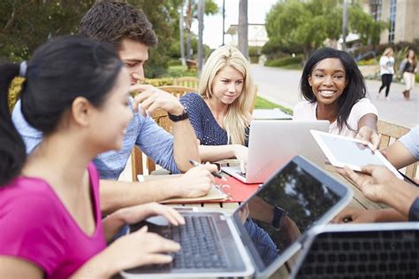 Group Of University Students Working On Project Outdoors Background