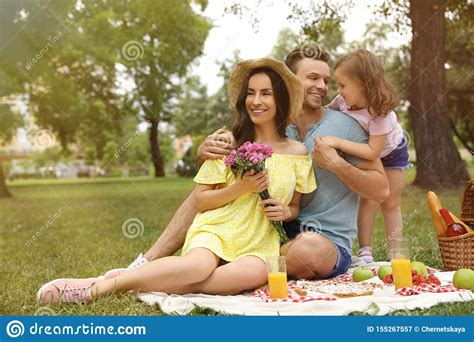 Familia Feliz Que Tiene Comida Campestre En Parque Imagen De Archivo