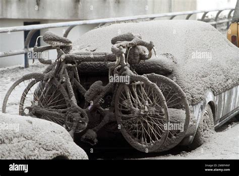 Ash Blankets An Automobile And The Two Bicycles Hanging On Its Bumper