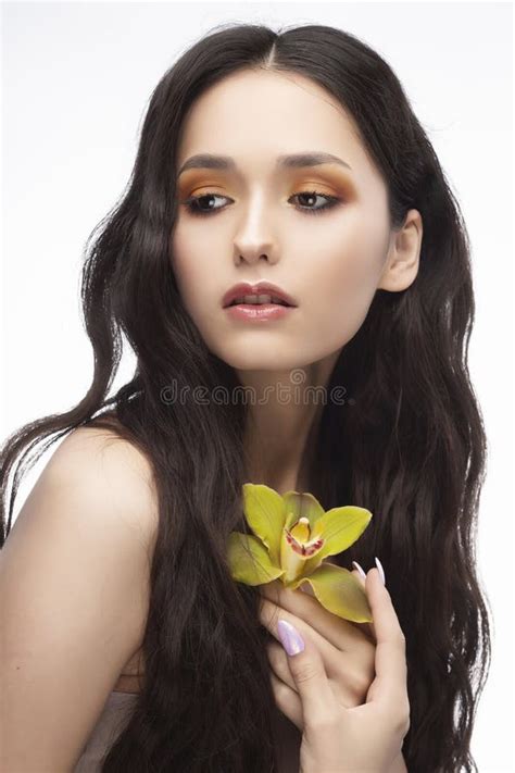 Uma Menina Moreno Bonita Dos Ombros Do Nude Guarda Sensualmente Um Flowe Imagem De Stock