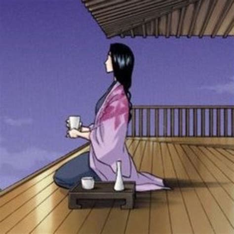 A Woman Sitting On Top Of A Wooden Floor Holding A Cup