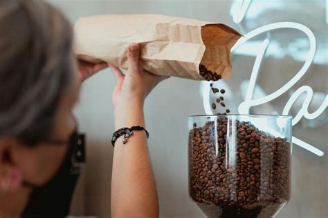 Photo Of Barista Pouring Fresh Coffee Beans On Coffee Grinder · Free