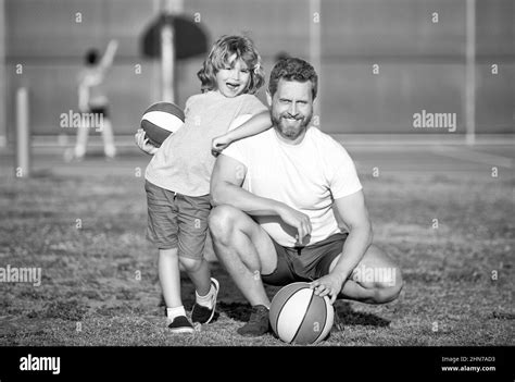 feliz padre y niño jugando baloncesto con pelota al aire libre