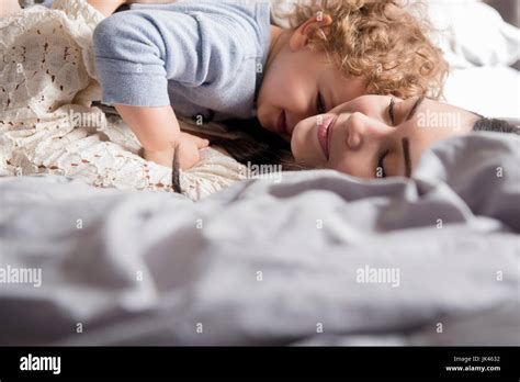 Caucasian Mother Laying On Bed Hugging Son Stock Photo Alamy