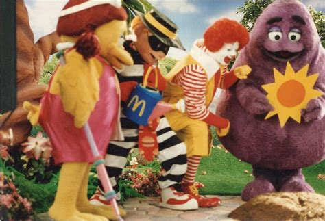 Ronald Mcdonald And His Friends Plant A Small Golden Arch In The Ground