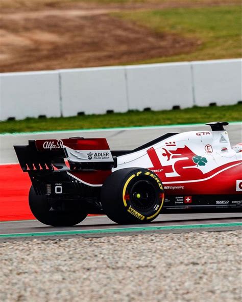 A Red And White Race Car Driving On A Track