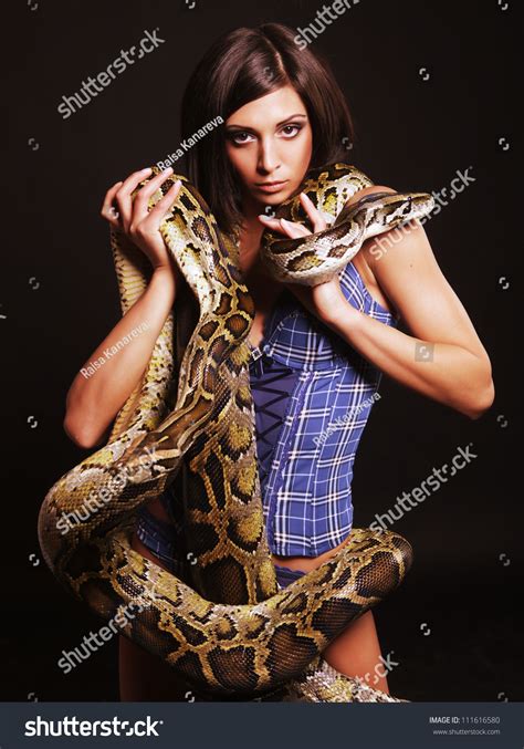 Sexy Brunette Holding Python Over Black Background Stock Photo