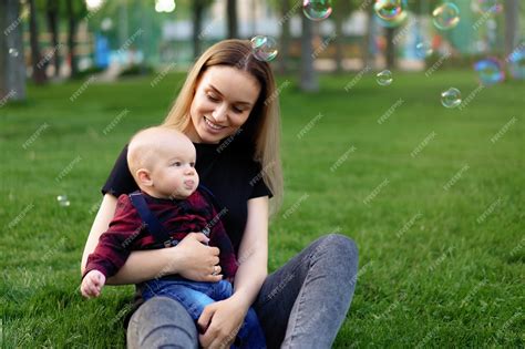 Premium Photo Young Caucasian Mother Inflates Soap Bubbles With Her