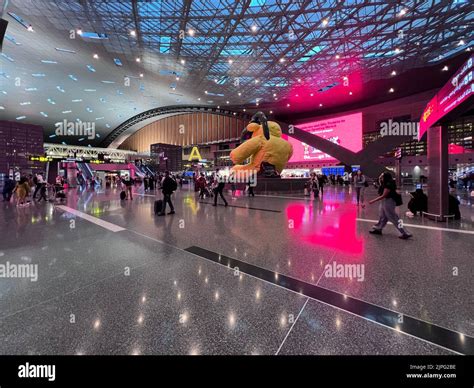 Interior Of Hamad International Airport Terminal Full Of Tourist People Passenger Big Yellow