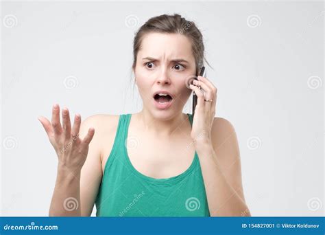 Woman Complaining While Talking On Smartphone Confused And Puzzled