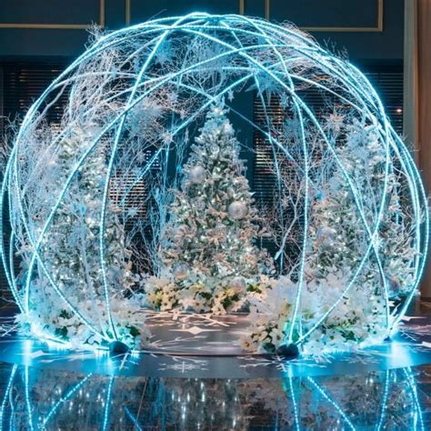 A Christmas Display With Lights In The Shape Of A Snow Globe And Trees