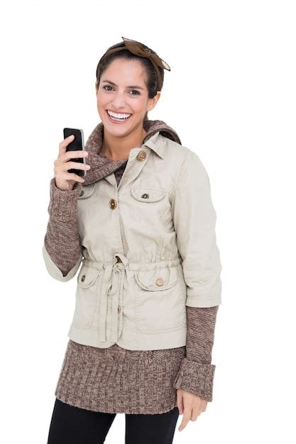 Premium Photo Smiling Cute Brunette In Winter Fashion Holding Smartphone
