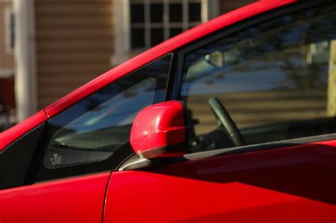 O espelho retrovisor do carro refletindo uma estrada panorâmica atrás o