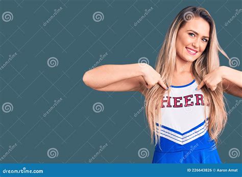 Young Beautiful Blonde Woman Wearing Cheerleader Uniform Looking