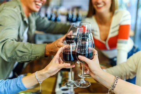 Crop And Unrecognizable Friends Clinking Wineglasses In Restaurant