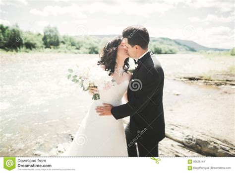 Beautifull Wedding Couple Kissing And Embracing Near The Shore Of A