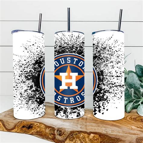 Three Houston Astros Tumblers Sitting On Top Of A Wooden Table Next To