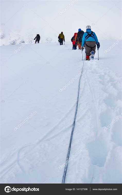 Alpinists hiking in snowy mountains Stock Photo by ©kovalvs 141127306