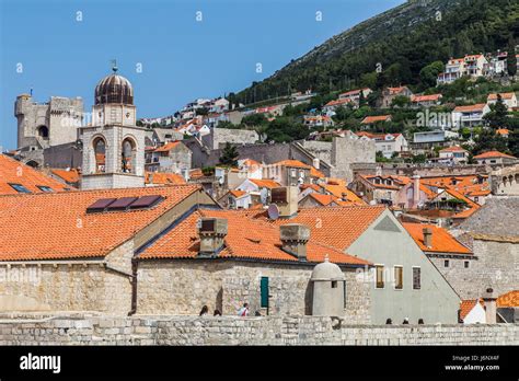 Tourists Explore The Ancient City Walls Of Dubrovnik In A Clockwise