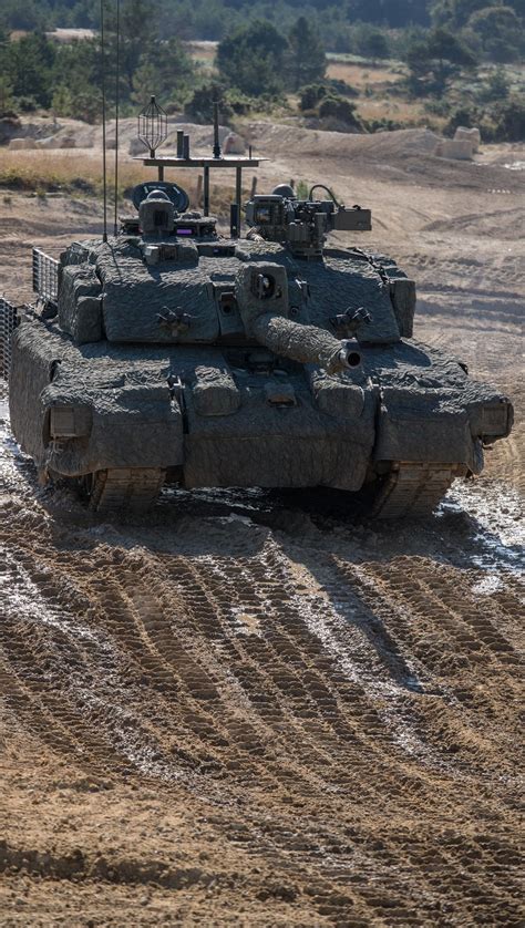 An Army Tank Is Driving Through Mud