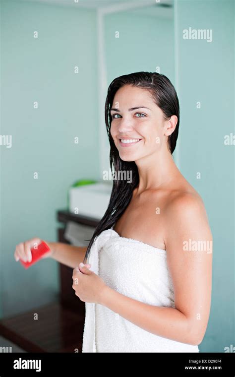 Brunette Woman Brushing Her Hair And Smiling At Camera Stock Photo Alamy