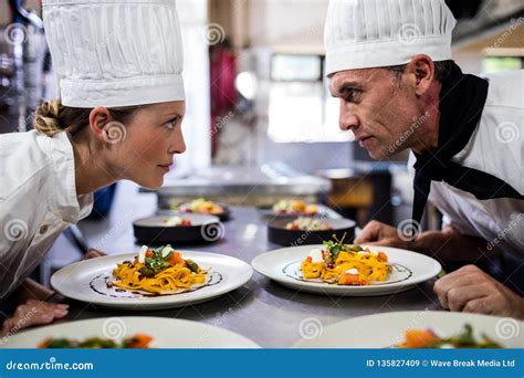 Mannelijke En Vrouwelijke Chef Koks Die Elkaar In Keuken Bekijken Stock