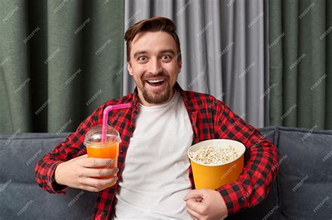 Premium Photo Excited Guy With Drink And Popcorn Watching Movie