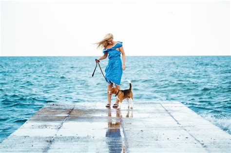 Jeune Belle Fille Blonde Marchant Jouant Avec Un Chien Beagle Au Bord De Mer Photo Gratuite