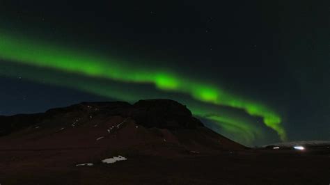 Aurora borealis over ring road highway with cars passing leave light ...
