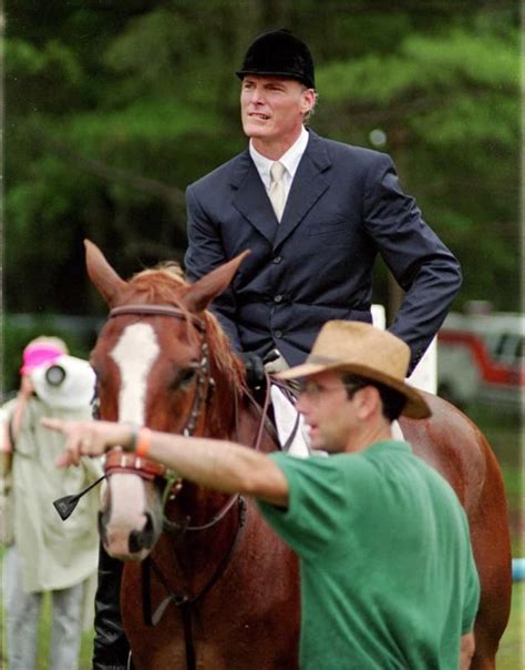 A Man In A Suit Riding On The Back Of A Brown Horse Next To Another Man