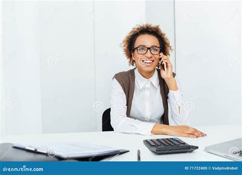 Happy African Woman Accountant Sitting And Talking On Cell Phone Stock