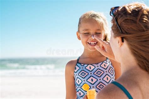 M E Que Aplica A Lo O Para Bronzear Na Cara Da Filha Foto De Stock