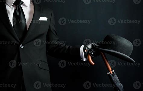 Portrait Of British Businessman In Dark Suit Holding Umbrella And