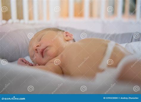 A Baby Boy Sleeps In A Cocoon On A Cot A Newborn Baby In A Diaper Is Lying Naked On The Bed