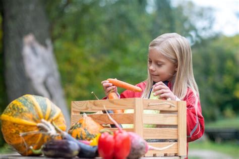 Premium Photo Long Haired Blonde Girl Looking Busy While Sorting Veggies