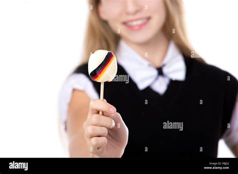 Happy cute belle fille blonde vêtu de noir tenue formelle avec bowtie montrant une sucette avec