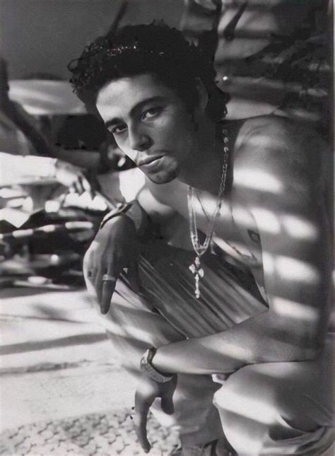 A Black And White Photo Of A Man Wearing Jewelry