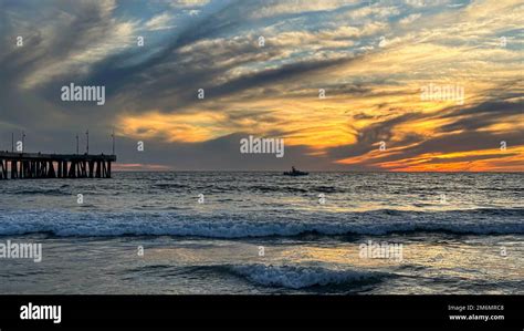 Colorful sunset lights up the beach, pier and ocean in Los Angeles ...