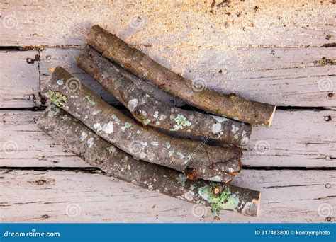 Pile Of Cut Logs Of Firewood Over A Wooden Boards Background Sawed