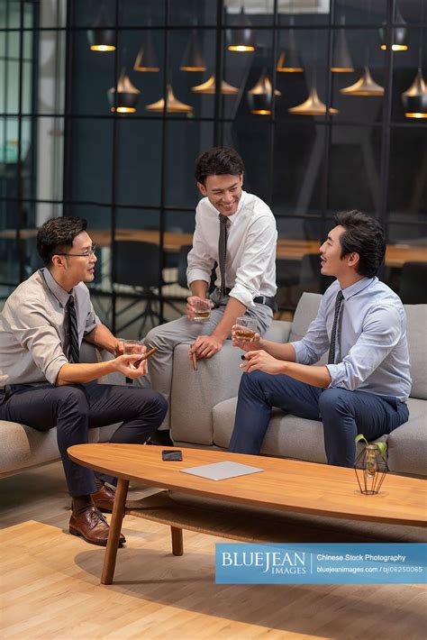 Successful Chinese Businessmen Drinking Alcohol In Office High Res