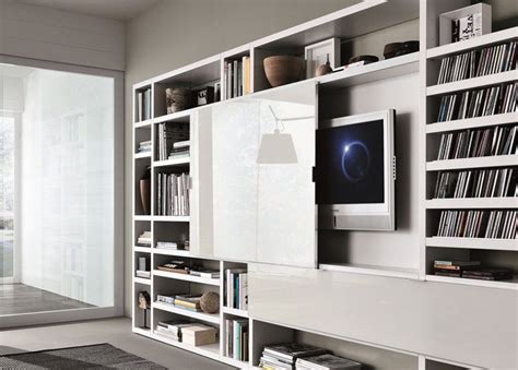 A Living Room With Bookshelves And A Flat Screen Tv Mounted On The Wall