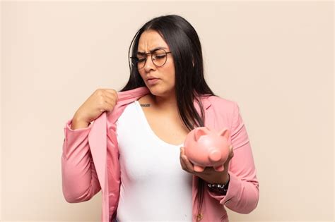 Joven latina sintiéndose estresada ansiosa cansada y frustrada tirando del cuello de la