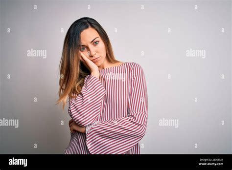 Jeune Belle Femme Blonde Avec Les Yeux Bleus Portant Le T Shirt Stipped Sur Fond Blanc Pensant