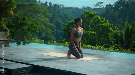 Stockvideo European Brunette Sports Girl Makes Yoga In Nature With A Green Rainforest On A Lit