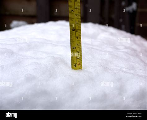 Tape measure in snow, showing Four (4) inches of snow Stock Photo - Alamy