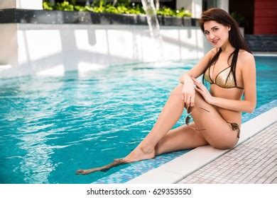 Beautiful Black Bikini Sitting By Pool Stock Photo