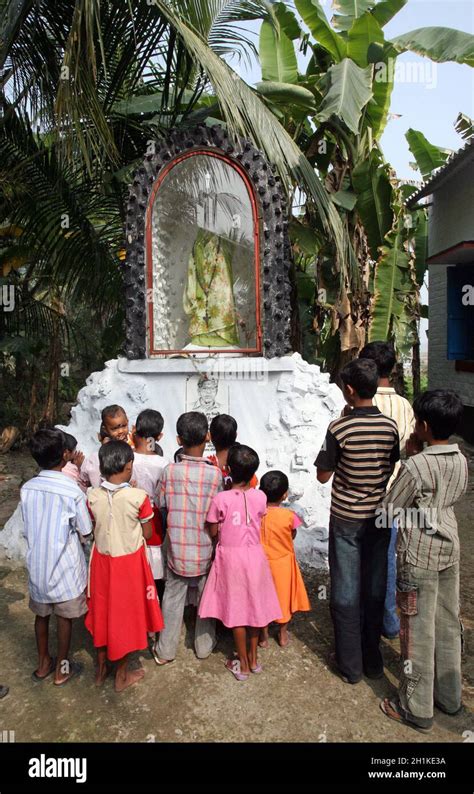 Group Of Young Bengali Catholics Pray Before A Statue Of The Blessed