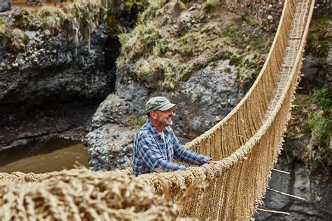 Male tourist looking out from Inca rope bridge, Cusco, Peru - Stock Image - F024/0873 - Science ...